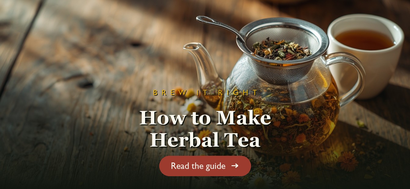 Loose dried herbs steeping in a glass teapot with a strainer on a wooden table